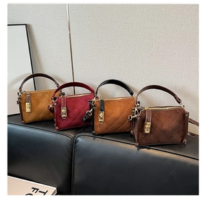 Close-up of quilted suede bags in yellow, burgundy, caramel, and dark brown with gold locks