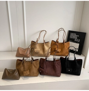 Group display of suede tote bags with knot handles in various earth tones and mini pouches
