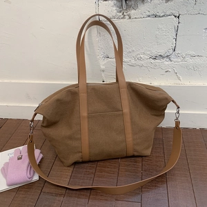 Vue détaillée du sac cabas en toile marron avec anses en cuir et fermeture éclair