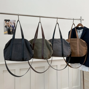 Large canvas tote bags in four colors shown hanging on a display for daily commuting