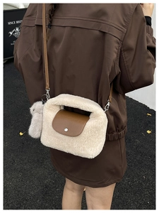 Detail of off-white faux shearling crossbody bag with brown leather flap and bunny charm