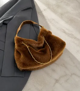 Dettaglio della borsa in peluche marrone con catena dorata e manico in finta pelle