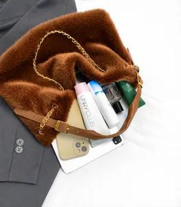 Dettaglio dell'interno spazioso della borsa in ecopelliccia marrone con vari accessori