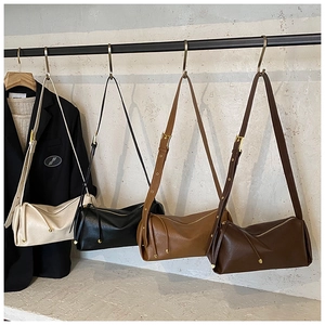 Détail de quatre sacs baguette minimalistes en crème, noir, caramel et marron avec cordon
