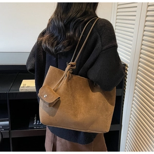 Close-up of caramel brown suede tote bag with matching mini pouch and long strap