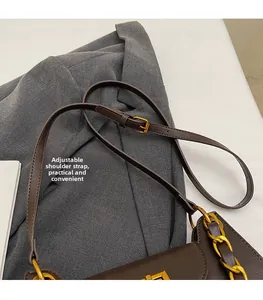 Détail du sac à main marron foncé avec bandoulière réglable et fermoir doré chic