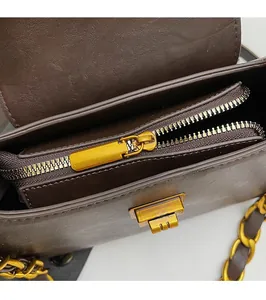 Détail de la fermeture éclair dorée et du compartiment intérieur du sac marron