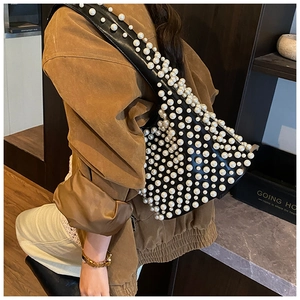 Detailansicht einer schwarzen Leder-Achseltasche mit weißen Perlen und goldener Schnalle