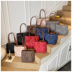Detail of waterproof nylon tote bags with leather handles in various neutral colors