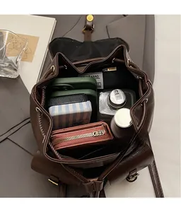 Dettaglio degli ampi interni dello zaino marrone vintage con vari oggetti personali