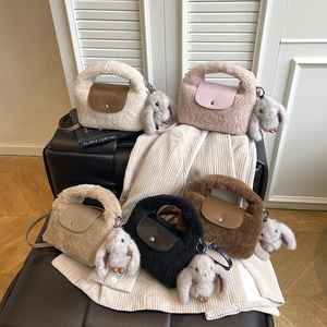 Close-up of plush fringe handbags in multiple colors with cute rabbit doll pendants