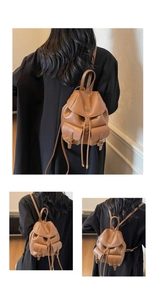 Dettaglio mini zaino vintage in pelle marrone con due tasche frontali e chiusura a cordoncino