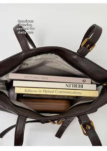Vista interna di una capiente borsa tote in pelle PU marrone con tasca a zip e accessori