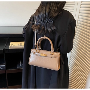 Détails du sac bandoulière kaki avec fermoir tournant doré et texture cuir élégante
