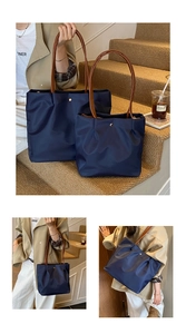 Detailed view of navy nylon tote bags with brown handles in large and small sizes