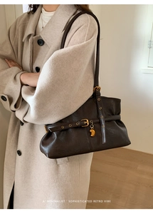 Dettaglio della borsa tote marrone vintage con cinturini e ciondolo a cuore in metallo