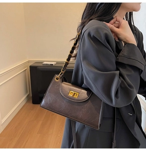 Détail du sac à bandoulière marron foncé avec fermoir doré et texture en similicuir