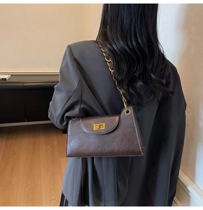 Détail d'un sac à main en cuir marron foncé avec fermoir doré vintage et chaîne