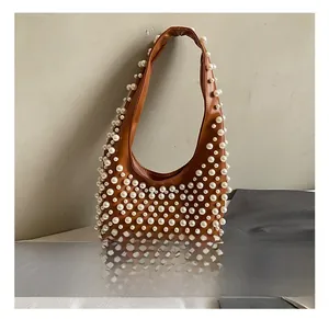 Detail einer braunen Hobo-Tasche aus PU-Leder mit dichten weißen Perlen und Trageriemen