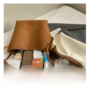 Nahaufnahme des geräumigen Innenraums einer Wildleder-Beuteltasche mit täglichen Utensilien