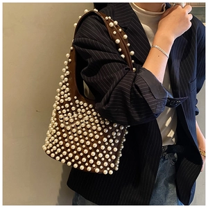 Detailaufnahme einer braunen Vintage-Tote-Bag mit eleganten weißen Perlenverzierungen