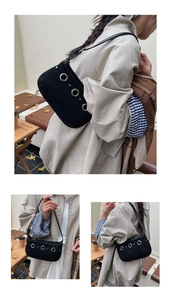 Détail du sac à bandoulière noir avec rivets en métal argenté et sangle minimaliste