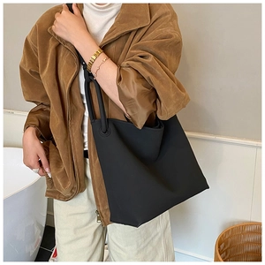 Makroaufnahme der minimalistischen schwarzen Wildleder-Beuteltasche mit runden Griffen