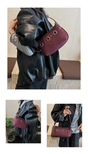 Détail du sac hobo en daim bordeaux avec trois œillets métalliques argentés emblématiques