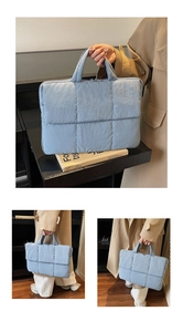 Macro shot of light blue quilted laptop bag texture with square stitching and double zippers