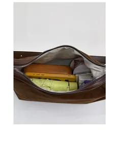 Interior view of brown suede shoulder bag showing large capacity and zipper pocket