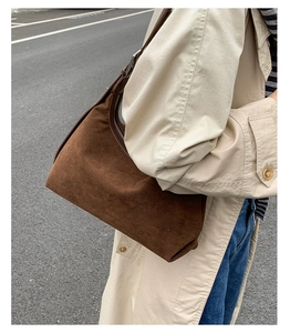 Outdoor street style shot showing side view of dark brown suede hobo bag details