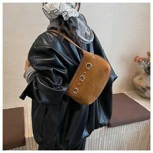 Detail view of brown suede shoulder bag with large silver metal rings on side