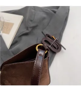 Détail du crochet en métal doré et du cuir marron sur le petit sac carré élégant