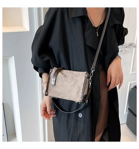 Detail view of khaki quilted crossbody bag with brown leather trim and silver buckle