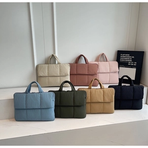 Detailed view of quilted laptop bags in multiple vibrant colors with a soft texture