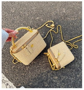 Detail of woven beige handbags featuring round gold handles and elegant metal chain straps