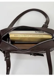 Detail view of the spacious inner compartment of the coffee leather shoulder bag