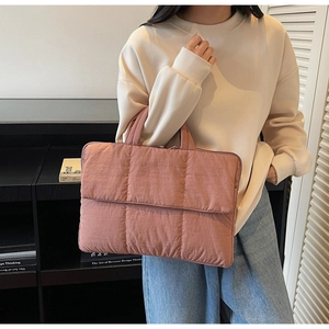 Detailed view of dusty pink quilted tote bag showing its padded texture and top handle