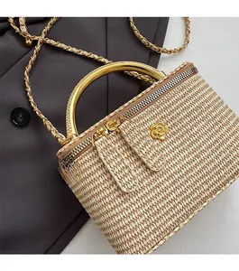 Close-up of woven straw handbag featuring gold floral hardware and metallic handles
