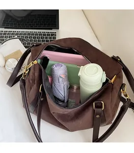 Intérieur spacieux du grand sac bandoulière en suède avec ordinateur et articles