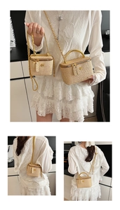 Detailed macro view of woven beige vanity case with gold handle and chain strap