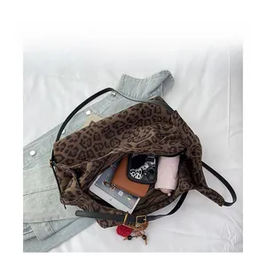 Interior view of leopard print tote bag showing storage for tablet, wallet, and umbrella