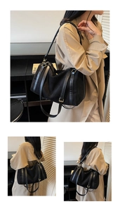 Détail du sac cabas en daim noir avec lanières en cuir et boucle dorée porté par un mannequin