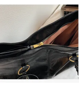 Detail des glatten Gold-Reißverschlusses und des Innenraums der schwarzen Shopper