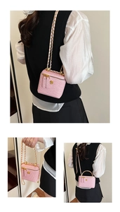 Detail of pink woven mini bag with gold camellia charm and metal chain strap shown on model