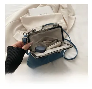 Detail of denim crossbody bag interior showing phone, earphones and lipstick capacity