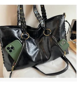 Detail der geölten Leder-Tote mit goldenen Metallringen und geflochtenen Tragegriffen