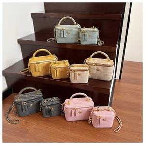 Close-up of woven texture vanity bags with chain straps in assorted stylish colors