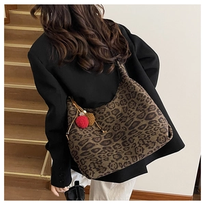 Detail of leopard print tote bag featuring fluffy pom-pom charm and large capacity