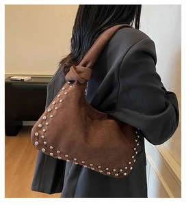 Detail of brown suede tote with silver studs and decorative knotted shoulder strap